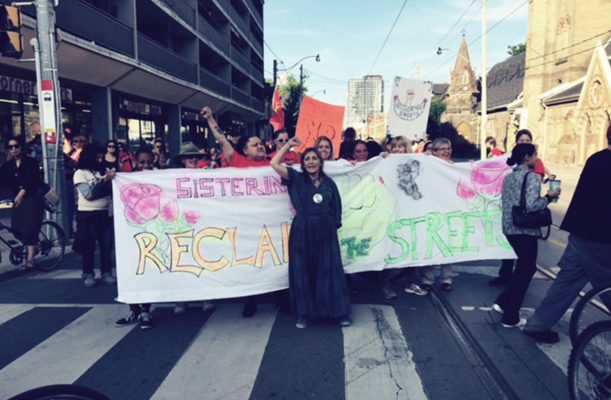 Group of protesters holding a Sistering Sign